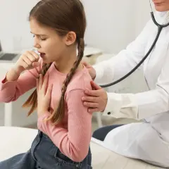 Bambina con tosse notturna, tossisce mentre il medico la ascolta con lo stetoscopio.