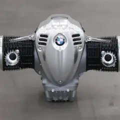 Motor boxer BMW plateado con aletas de refrigeración negras y el logo de BMW en el centro.