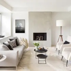 Nowoczesny styl nowojorski salon z szarą sofą, betonowym kominkiem i obrazem gór lodowych.