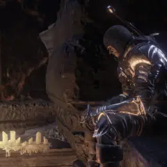 Rycerz w zbroi siedzi przy świecach, szukając wskazówek w mrocznym świecie. To może być kluczowy moment w twoim **dark souls poradnik**.