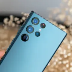 Dłoń trzyma niebieski Samsung z modułem aparatów. To prawdziwy **expert raw samsung** do fotografii.