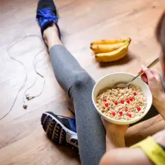 Après l'effort, un bol de flocons d'avoine avec des fruits rouges, une collation parfaite pour une nourriture healthy. Des bananes et un téléphone à proximité.