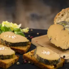 Tranches de foie gras sur toasts, accompagnées de salade verte, pain frais et confiture. La cuisson du foie gras est parfaite.