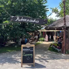 Rybaczówka zaprasza na sielawę. Letni ogródek z drewnianymi stołami i strzechą zachęca do odpoczynku.