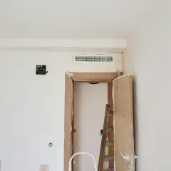 Instalación de rejilla para montaje de aire acondicionado sobre puerta en obra.