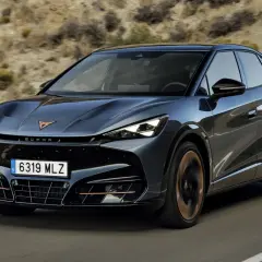 Ciemnoszary Cupra Tavascan jedzie po drodze. Sprawdź aktualną cupra tavascan cena i dowiedz się więcej o tym stylowym SUV-ie coupe.