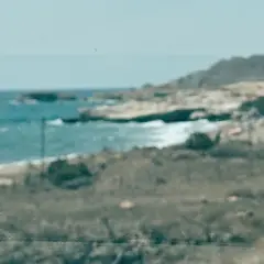 Vista de la playa de los Genoveses, con el mar azul y las colinas. Un lugar ideal para disfrutar y comer algo.