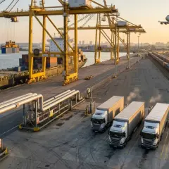 Portowy plac z kontenerowcem, ciężarówkami, pociągiem i samolotem na niebie. Różne rodzaje transportu w akcji.