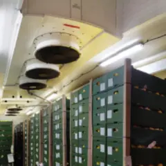 Almacén con cajas apiladas y ventiladores en el techo para el sistema de refrigerante CO2.