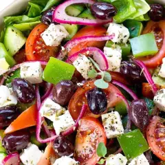 Insalata greca colorata con cubetti di feta, pomodori, olive, cetrioli e cipolla rossa. Il sapore fresco e mediterraneo è invitante.