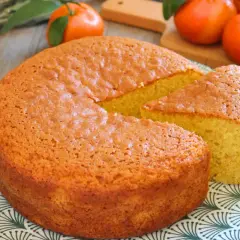 Bizcocho de mandarina esponjoso y dorado, con una porción cortada, listo para disfrutar.
