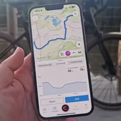 Mapa z trasą rowerową na telefonie, pokazująca drogi leśne dopuszczone do ruchu. Widok profilu wysokości i przycisk "Jedź".