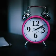 Różowy budzik na stoliku przypomina o ciszy nocnej w bloku. Jest późno, czas na sen.