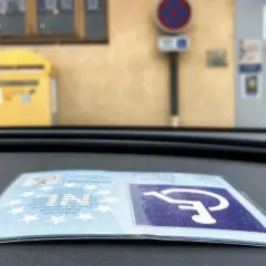 Karta parkingowa dla niepełnosprawnych uprawnienia, symbol wózka inwalidzkiego na niebieskim tle.