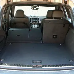Maletero de un Porsche Cayenne, mostrando su amplitud y los asientos traseros abatibles. Ideal para conocer las porsche cayenne medidas de carga.
