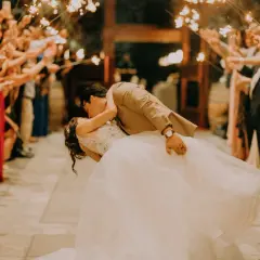 Coppia si bacia tra scintille di bengala, circondata da invitati festanti. Un momento magico, come i migliori giochi matrimonio.