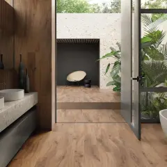 Bagno moderno con vasca freestanding, doppio lavabo e piante rigogliose. Un esempio di raffinate ristrutturazioni interne che uniscono natura e design.