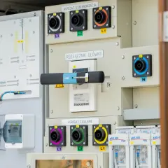 Panel sterowania z rozłącznikiem głównym i agregatami synchronizacji i zasilania. Widoczne złącza L1, L2, L3, N oraz bezpieczniki. System wykorzystuje izolację SF6.