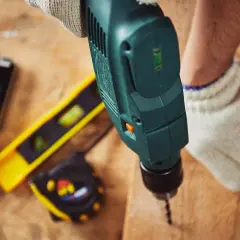 Une perceuse sert à faire des trous dans le bois, comme le montre cette image avec d'autres outils de bricolage.