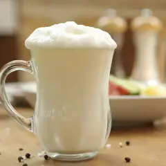 Puszysty ayran w szklance, idealny napój na upalne dni. Czy wiesz, ayran co to? To orzeźwiający napój jogurtowy.