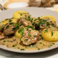 Polędwiczki w sosie pieczarkowym z ziemniakami, posypane natką pietruszki. Pyszne danie obiadowe.