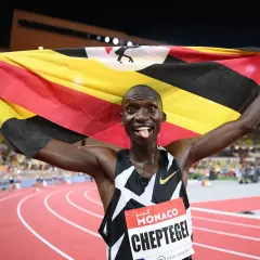 Joshua Cheptegei z flagą Ugandy świętuje swój rekord świata na 5km.