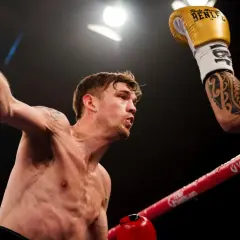 Sven Fornling i en intensiv boxningsmatch, med en röd handske höjd i luften.