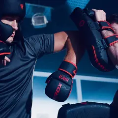 Two boxers train intensely, practicing punches and blocks. This image captures the spirit of a professional boxing round length, showcasing dedication and skill.