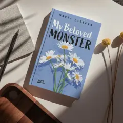 Okładka książki "My Beloved MONSTER" Marty Łabeckiej, z motywem stokrotek. To piękna miłość książka dla dzieci, która zachwyci najmłodszych.