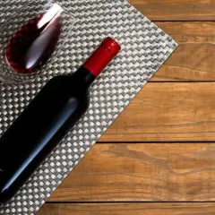 Ciemnoczerwone wino w kieliszku i butelce, gotowe do degustacji przez sommeliera.