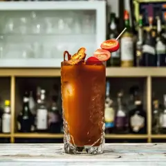 Orzeźwiający drink Krwawa Mary z pomidorkami i suszonymi papryczkami, gotowy do podania na barze.