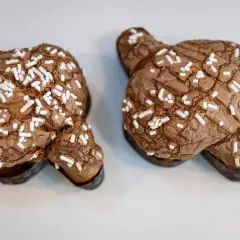 Dos deliciosas colomba de chocolate, cubiertas de azúcar perlado, listas para ser disfrutadas.