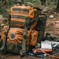 Mochila táctica naranja y verde con accesorios de supervivencia, lista para la aventura.