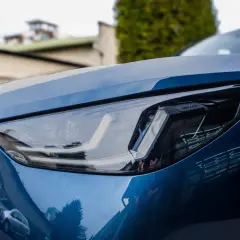 Błyszczący, niebieski lakier BMW z nowoczesnym reflektorem LED. Detailing podkreśla jego sportowy charakter.