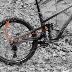 Close-up of a high pivot mtb's rear suspension, showing the complex linkage system and shock absorber. Orange arrows highlight the pivot path.