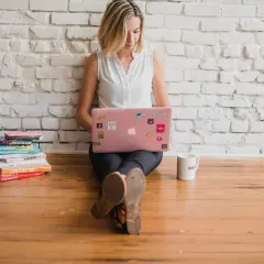 Kvinna med laptop och böcker, kanske redo att skriva en bok om sitt liv.