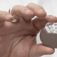 Dłoń trzymająca niewielki pacemaker. Dzięki niemu można wrócić do aktywności, nawet do biegania.