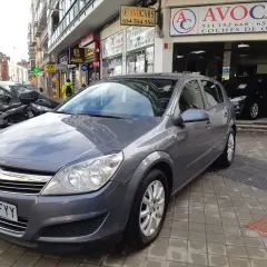 Opel Astra 1.7 CDTI 110CV gris aparcado frente a concesionario de coches de ocasión AVOCARS.