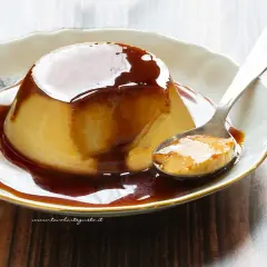 Delizioso creme caramel su un piatto bianco, con una cucchiaiata pronta da gustare.