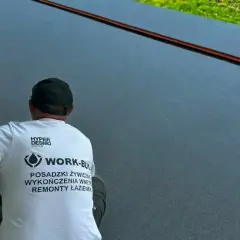 Pracownik w koszulce z logo firmy wykańcza nowoczesny taras z żywicy.