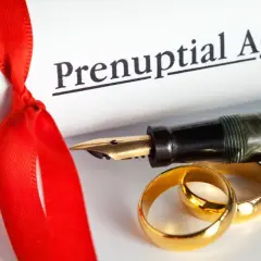 Złote obrączki i pióro na dokumencie "Prenuptial Agreement". Rozdzielność majątkowa koszt to ważna decyzja.