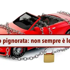 Auto rossa con catene e lucchetto, simbolo di pignoramento auto con finanziamento in corso.