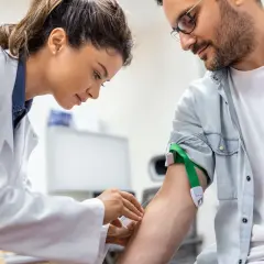 Pielęgniarka pobiera krew pacjentowi. To jego wizyta u lekarza w czasie pracy, szybka i sprawna.