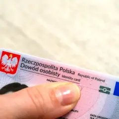 Dłoń trzyma polski dowód osobisty. Czy imię z bierzmowania jest w dowodzie? To pytanie nurtuje wielu Polaków.