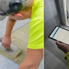 Byggare lägger klinker på ett badrumsgolv. En annan person kontrollerar arbetet på en surfplatta.