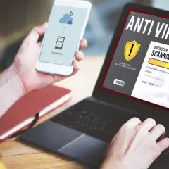 Osoba korzysta z laptopa z programem antywirus free, który skanuje komputer. Na telefonie widnieje komunikat o przesyłaniu danych.