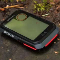 Sigma ROX GPS na leśnym pniu. Ten zaawansowany licznik rowerowy jest gotowy na każdą przygodę.