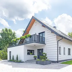 Nowoczesny biały dom z balkonem i zielenią. Idealne miejsce na realizację darmowe projekty domów.