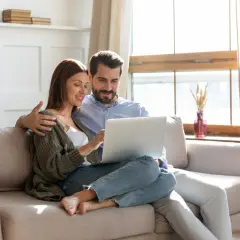 Couple planifiant l'amélioration de leur habitat, consultant un prêt sur leur ordinateur.