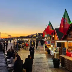 Serata vivace con bandiere portoghesi e bancarelle di cibo, un'atmosfera da club all'aperto a Lisbona.